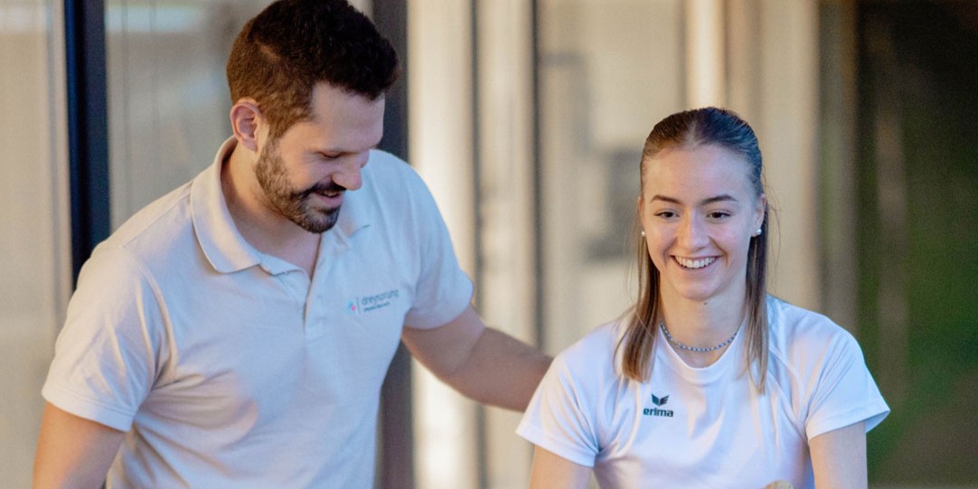 Physiotherapeut trainiert mit junger Frau das Seiltraining