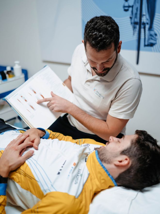 Physiotherapeut erklärt Sportler den Trainingsplan